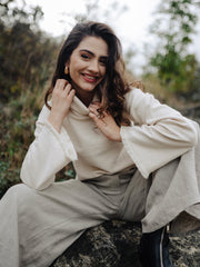 Smiling girl in sustainable fashion organic cotton turtle neck swetar and linen pants