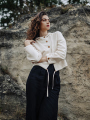 Girl in organic cotton buttoned Czucz Studio sweater and black linen pants